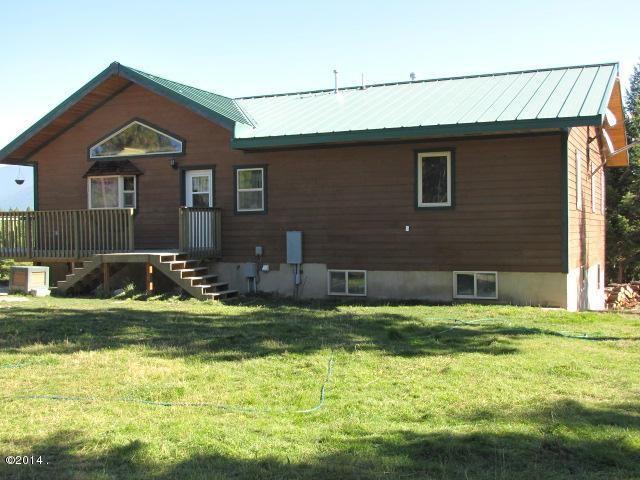 174 Badger Trl, Eureka, MT 59917 - back of house featuring a yard, metal roof, stairs, and a standing seam roof