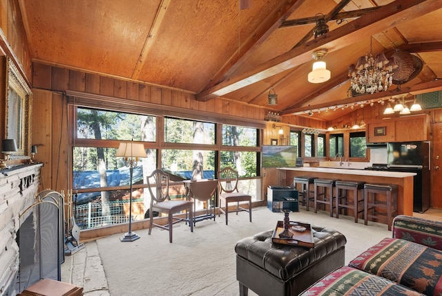 living room with carpet flooring, wood walls, wood ceiling, a fireplace, and a chandelier