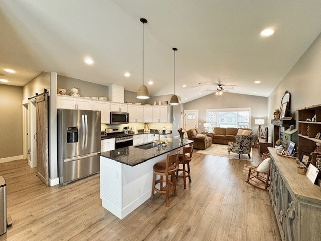 3975 Jaycee Ct Unit B, East Helena, MT 59635 - kitchen featuring appliances with stainless steel finishes, a sink, vaulted ceiling, white cabinetry, and light wood-type flooring