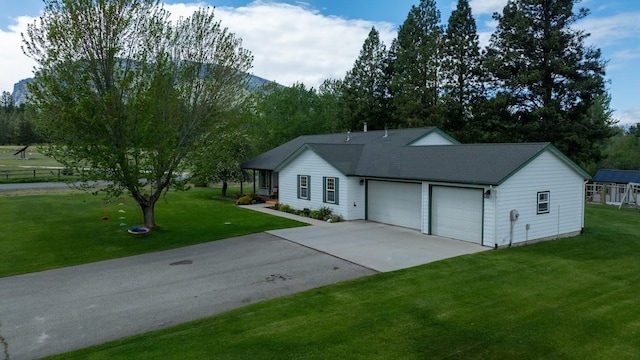 ranch-style home featuring concrete driveway, an attached garage, a front lawn, and roof with shingles