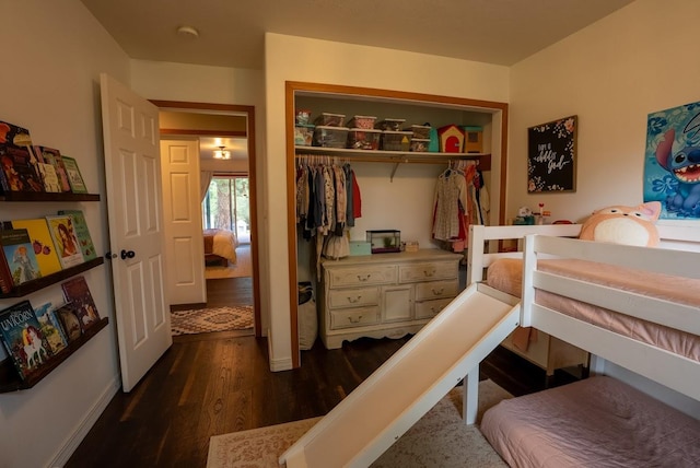bedroom featuring dark wood-style floors, a closet, and baseboards