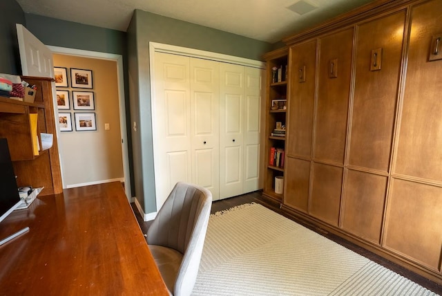 unfurnished office featuring dark wood-style floors and baseboards