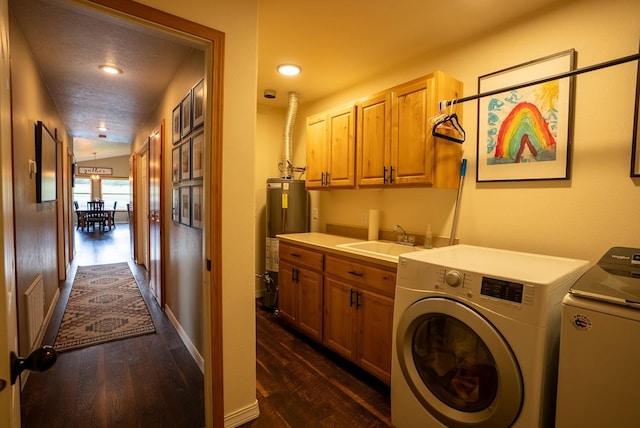 clothes washing area with washing machine and dryer, water heater, cabinet space, dark wood-type flooring, and recessed lighting