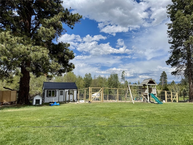view of yard with a storage unit, a playground, and an outbuilding