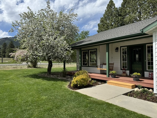 view of green lawn featuring covered porch