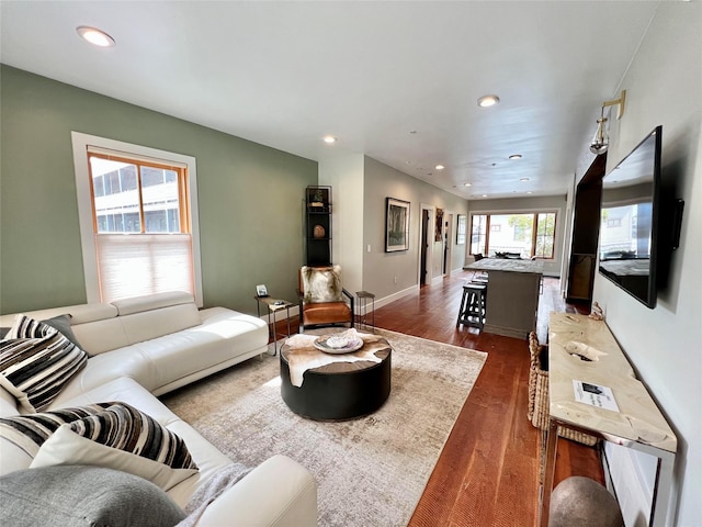 living room featuring recessed lighting, wood finished floors, and baseboards