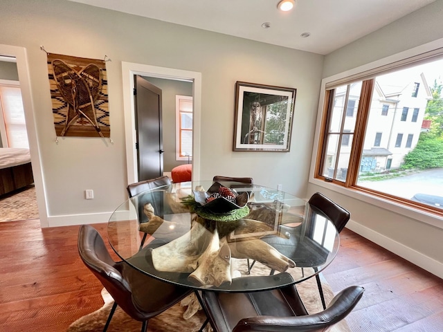 dining space with baseboards and wood finished floors