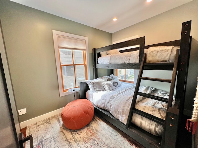 bedroom with baseboards, wood finished floors, and recessed lighting