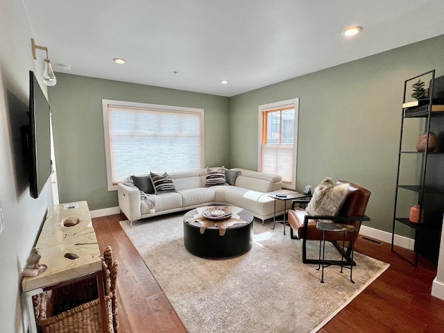 living area with wood finished floors, baseboards, and recessed lighting