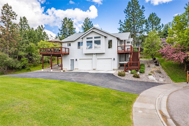 view of front of house featuring a deck, stairs, asphalt driveway, and a garage