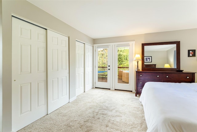 bedroom with access to exterior, carpet flooring, two closets, and french doors