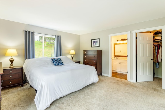 bedroom with carpet, ensuite bathroom, a walk in closet, and a closet