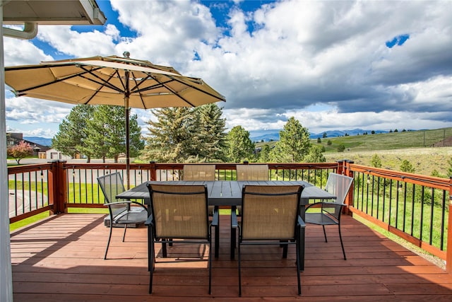 wooden deck featuring outdoor dining area and a mountain view