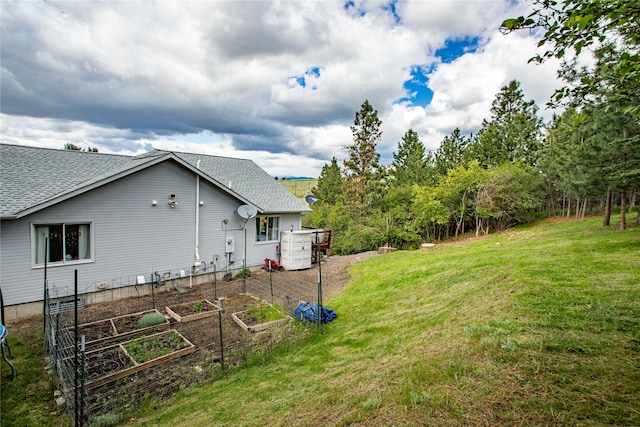 view of grassy yard with a vegetable garden