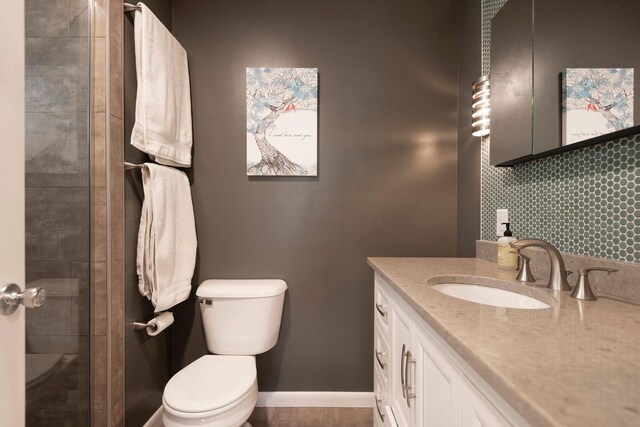 500 Geddis St, Helena, MT 59601 - bathroom with toilet, vanity, a tile shower, and baseboards