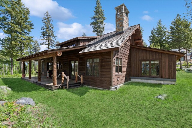 124 Trading Post Trl, Bigfork, MT 59911 - back of property featuring a lawn and a chimney