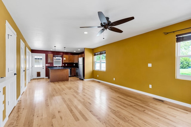 unfurnished living room featuring light wood-type flooring, baseboards, ceiling fan, recessed lighting, and a sink