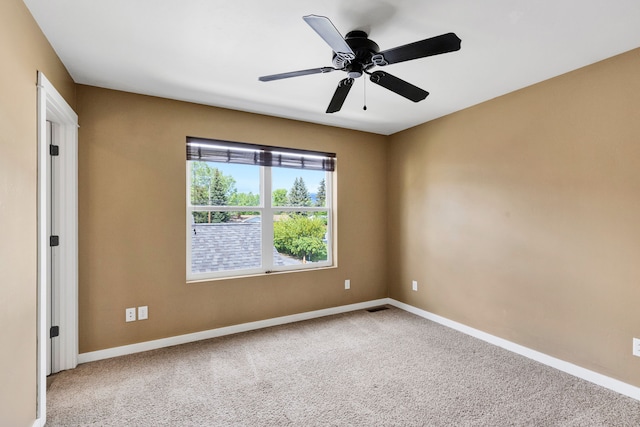 carpeted empty room featuring baseboards and a ceiling fan