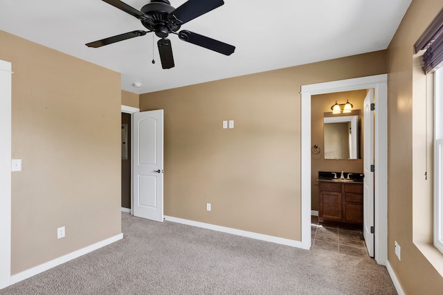 unfurnished bedroom featuring light carpet, a sink, baseboards, and connected bathroom