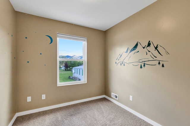 spare room featuring baseboards and carpet flooring