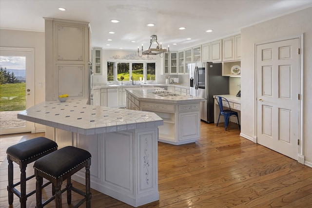 215 Browns Gulch Rd, Kalispell, MT 59901 - kitchen featuring stainless steel fridge with ice dispenser, a peninsula, a kitchen breakfast bar, a center island, and crown molding