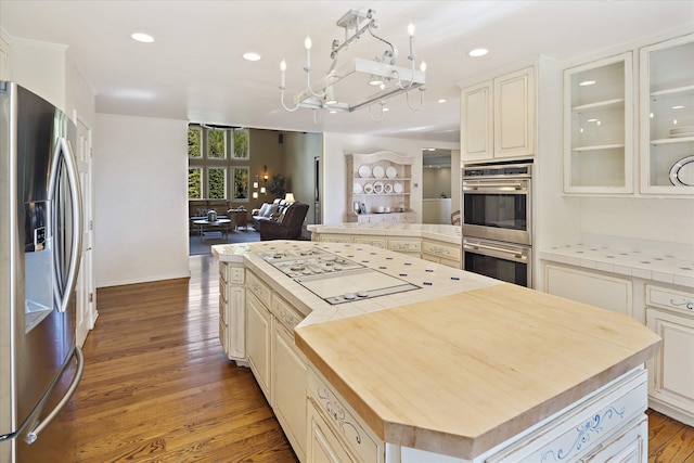 215 Browns Gulch Rd, Kalispell, MT 59901 - kitchen featuring stainless steel appliances, open floor plan, a kitchen island, wood counters, and a chandelier