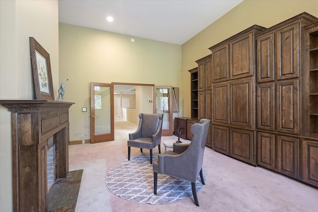 215 Browns Gulch Rd, Kalispell, MT 59901 - living area with light carpet, a fireplace with flush hearth, a towering ceiling, and baseboards