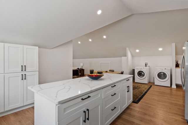 215 Browns Gulch Rd, Kalispell, MT 59901 - kitchen with separate washer and dryer, lofted ceiling, white cabinets, light stone countertops, and a center island