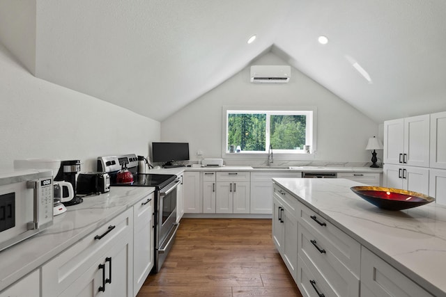 215 Browns Gulch Rd, Kalispell, MT 59901 - kitchen featuring appliances with stainless steel finishes, a wall mounted AC, white cabinetry, wood finished floors, and lofted ceiling