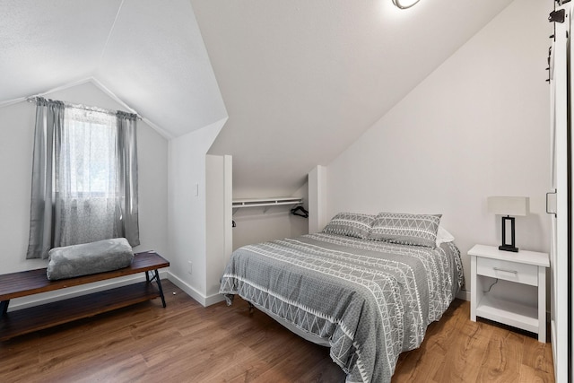 215 Browns Gulch Rd, Kalispell, MT 59901 - bedroom with lofted ceiling, wood finished floors, and baseboards