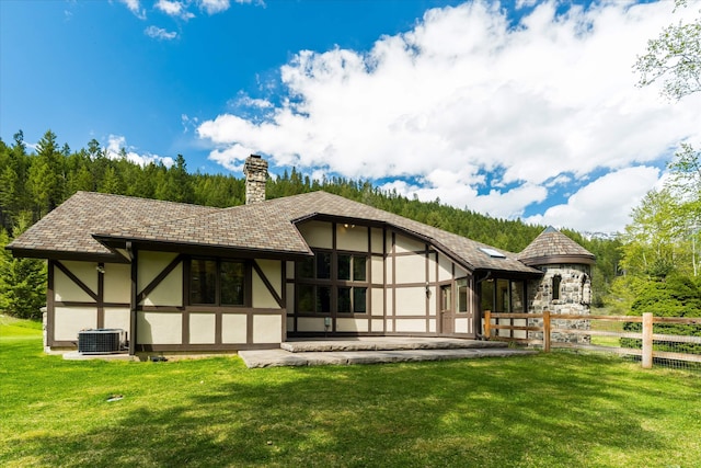 215 Browns Gulch Rd, Kalispell, MT 59901 - back of house with stucco siding, central AC, and a chimney