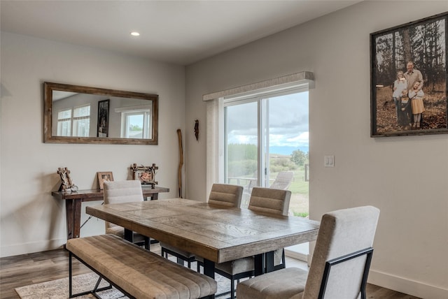 dining room featuring baseboards, wood finished floors, and recessed lighting