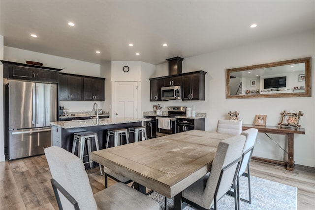 dining room with recessed lighting, light wood-type flooring, and baseboards