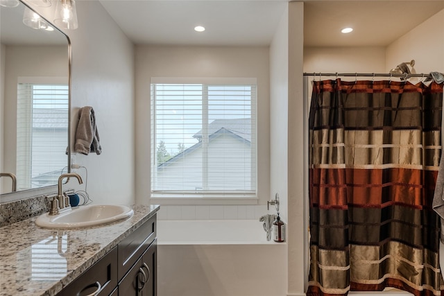 bathroom with vanity, a garden tub, a shower with curtain, and recessed lighting