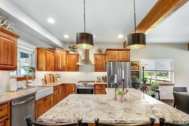 11818 Stella Blue Dr, Lolo, MT 59847 - kitchen with appliances with stainless steel finishes, a sink, wall chimney exhaust hood, light stone counters, and brown cabinets