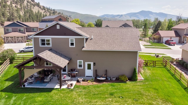11818 Stella Blue Dr, Lolo, MT 59847 - rear view of house with roof with shingles, a mountain view, and a patio area
