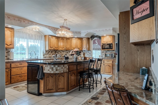 527 Grande Vista Dr, Kalispell, MT 59901 - kitchen with black microwave, tasteful backsplash, plenty of natural light, and a chandelier