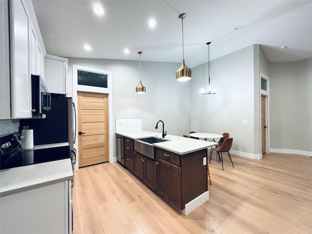687 Road Runner St Unit B, Helena, MT 59602 - kitchen featuring a sink, light countertops, dark brown cabinetry, light wood-type flooring, and recessed lighting
