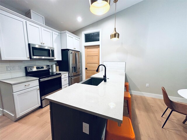 687 Road Runner St Unit B, Helena, MT 59602 - kitchen with stainless steel appliances, a sink, lofted ceiling, a kitchen breakfast bar, and white cabinets