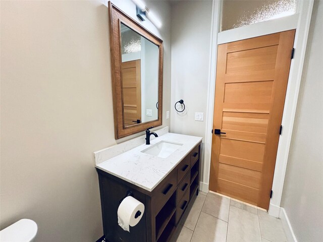 687 Road Runner St Unit B, Helena, MT 59602 - half bathroom featuring vanity, tile patterned floors, baseboards, and toilet
