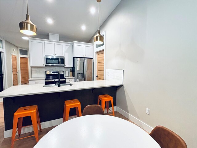687 Road Runner St Unit B, Helena, MT 59602 - kitchen featuring stainless steel appliances, a sink, a breakfast bar area, decorative backsplash, and recessed lighting