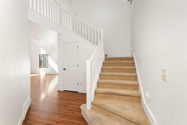 2060 Marina Ct, Bigfork, MT 59911 - staircase featuring wood finished floors, baseboards, and a towering ceiling