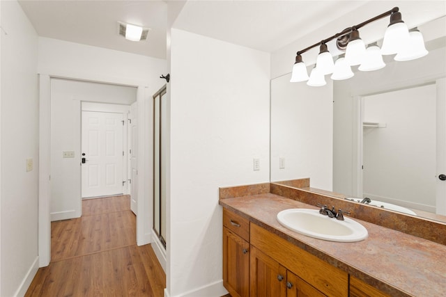 2060 Marina Ct, Bigfork, MT 59911 - bathroom featuring a stall shower, wood finished floors, vanity, and baseboards