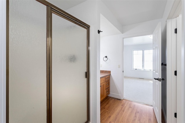 2060 Marina Ct, Bigfork, MT 59911 - full bathroom featuring wood finished floors, a stall shower, vanity, and baseboards