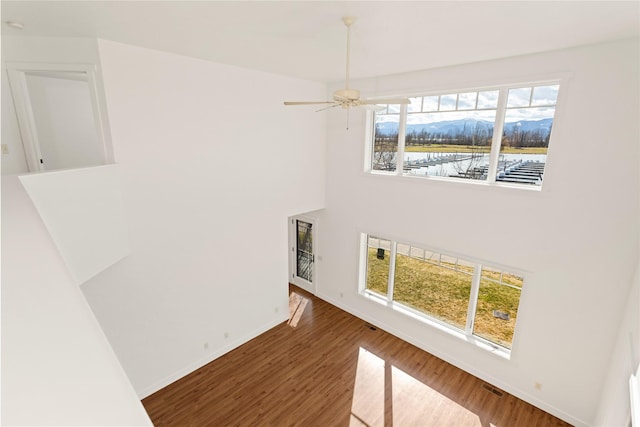 2060 Marina Ct, Bigfork, MT 59911 - spare room featuring wood finished floors, baseboards, a mountain view, and a high ceiling