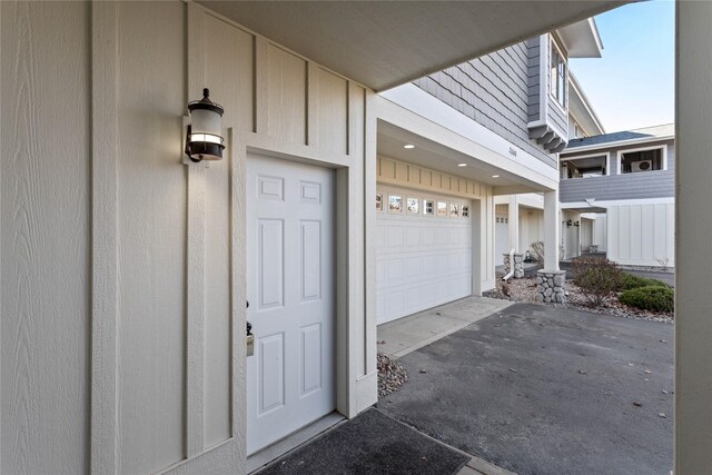 2060 Marina Ct, Bigfork, MT 59911 - view of exterior entry with driveway, a garage, and board and batten siding