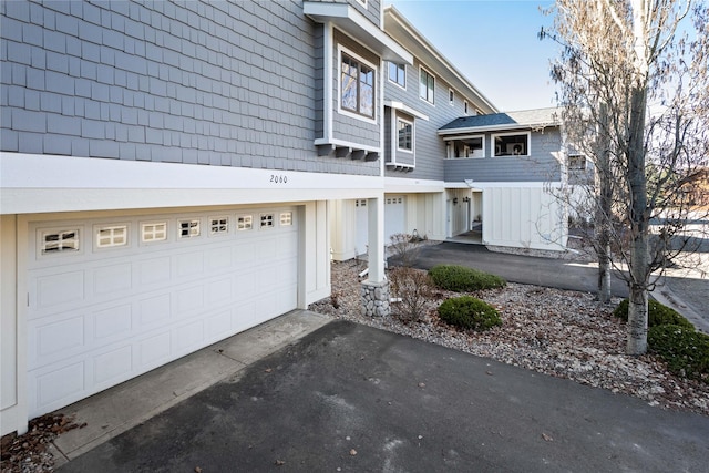 2060 Marina Ct, Bigfork, MT 59911 - view of side of property featuring asphalt driveway, a garage, and board and batten siding