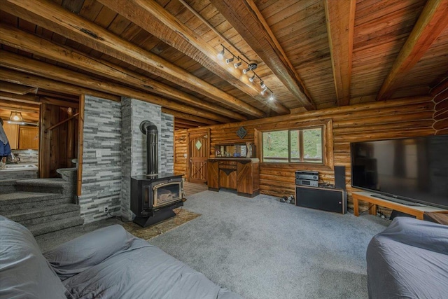 6470 US Highway 93 S, Eureka, MT 59917 - carpeted living room with a wood stove, a wood ceiling with exposed beams, log walls, stairs, and track lighting