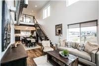 living room with a towering ceiling, wood finished floors, and stairway