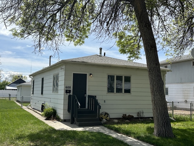 rear view of house featuring entry steps and roof with shingles